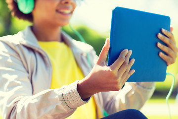 Image showing happy african woman with tablet pc and headphones