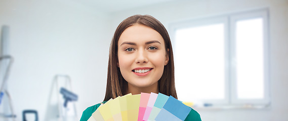 Image showing smiling young woman with color swatches