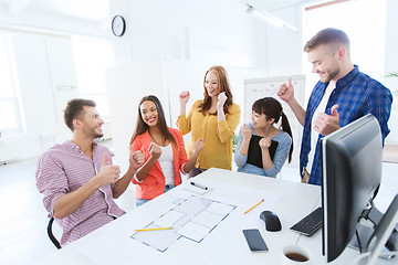 Image showing happy creative team celebrating success at office