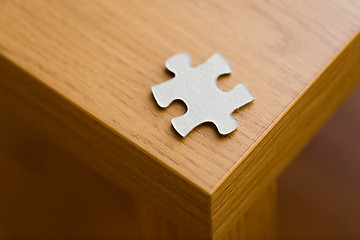 Image showing close up of puzzle piece on wooden surface