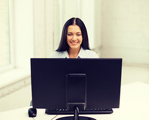 Image showing smiling businesswoman or student with computer