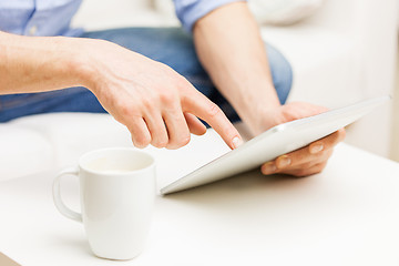 Image showing close up of man with tablet pc and tea cup at home