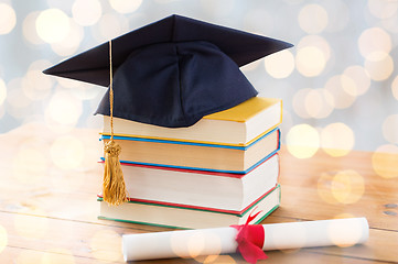 Image showing close up of books with diploma and mortarboard