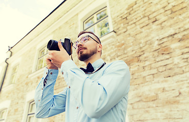 Image showing happy young hipster man with film camera in city