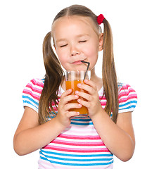 Image showing Little girl is drinking carrot juice