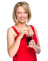 Image showing Young woman is drinking cherry juice