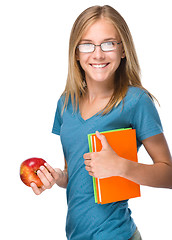 Image showing Young student girl is holding book and apple