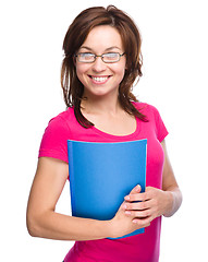 Image showing Young skinny student girl is holding exercise book