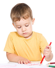 Image showing Little boy is drawing using color pencils