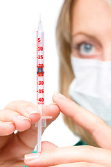 Image showing Young nurse is preparing syringe for injection