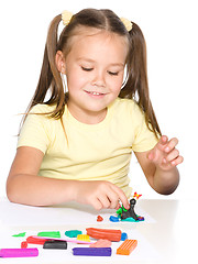 Image showing Little girl is playing with plasticine