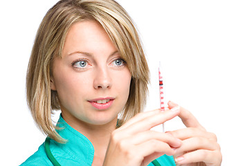 Image showing Young nurse is preparing syringe for injection