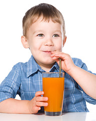 Image showing Little boy with glass of carrot juice