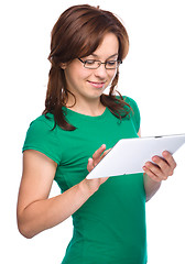 Image showing Young cheerful woman is using tablet