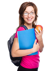 Image showing Young student girl is holding book and apple