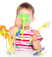 Image showing Boy is playing with artificial flowers toys