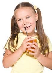 Image showing Little girl is drinking carrot juice