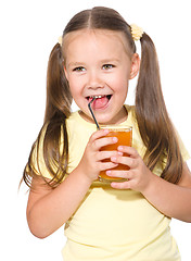 Image showing Little girl is drinking carrot juice