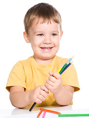 Image showing Little boy is playing with color pencils