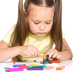 Image showing Little girl is playing with plasticine