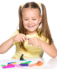 Image showing Little girl is playing with plasticine