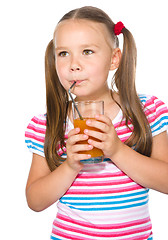 Image showing Little girl is drinking carrot juice