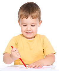 Image showing Little boy is drawing using color pencils