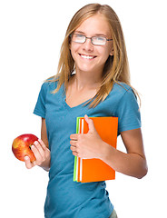 Image showing Young student girl is holding book and apple