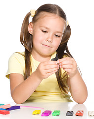 Image showing Little girl is playing with plasticine