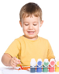 Image showing Little boy is playing with paints