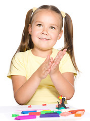 Image showing Little girl is playing with plasticine