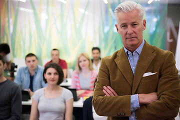 Image showing portrait of  teacher with students group in background