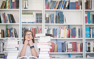 Image showing female student study in library, using tablet and searching for 