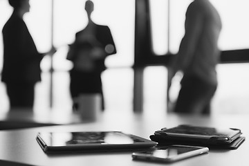 Image showing close up of tablet, business people on meeting in background