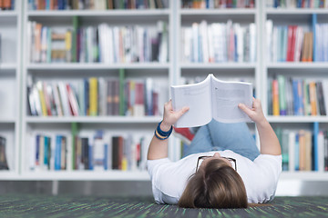 Image showing female student study in library, using tablet and searching for 