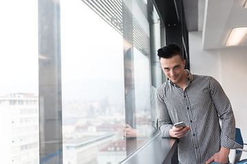 Image showing young business man using smart phone at office