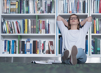 Image showing female student study in library, using tablet and searching for 