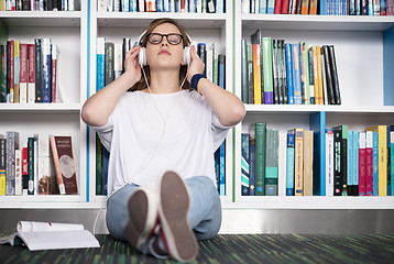 Image showing female student study in library, using tablet and searching for 