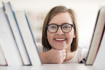 Image showing portrait of famale student selecting book to read in library