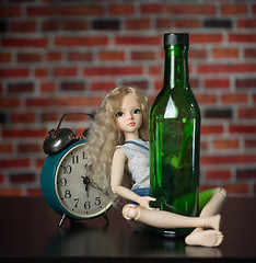 Image showing doll with a bottle. the concept of alcoholism