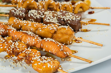 Image showing Grilled juicy skewered shashlik on a plate, sesame