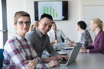 Image showing young business couple working on laptop, businesspeople group on