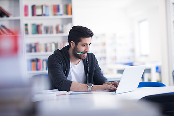 Image showing student in school library using laptop for research