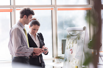 Image showing young couple working on flip board at office