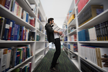 Image showing Student holding lot of books in school library