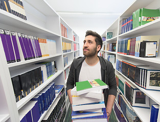 Image showing Student holding lot of books in school library