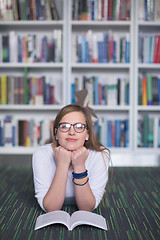 Image showing female student study in library, using tablet and searching for 