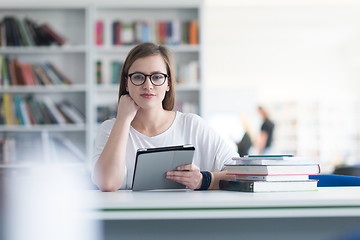 Image showing female student study in school library, using tablet