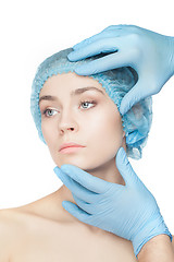 Image showing Plastic surgery concept. Doctor hands in gloves touching woman face