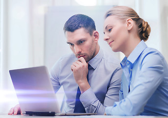 Image showing serious business couple with laptop computer